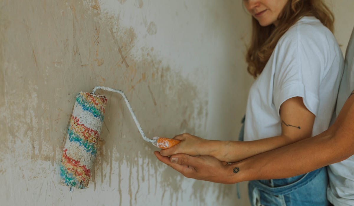 Maler bei Innenmalerei — Wand wird frisch gestrichen