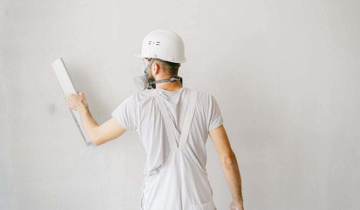 Handwerker beim Verputzen — Wand wird geglättet